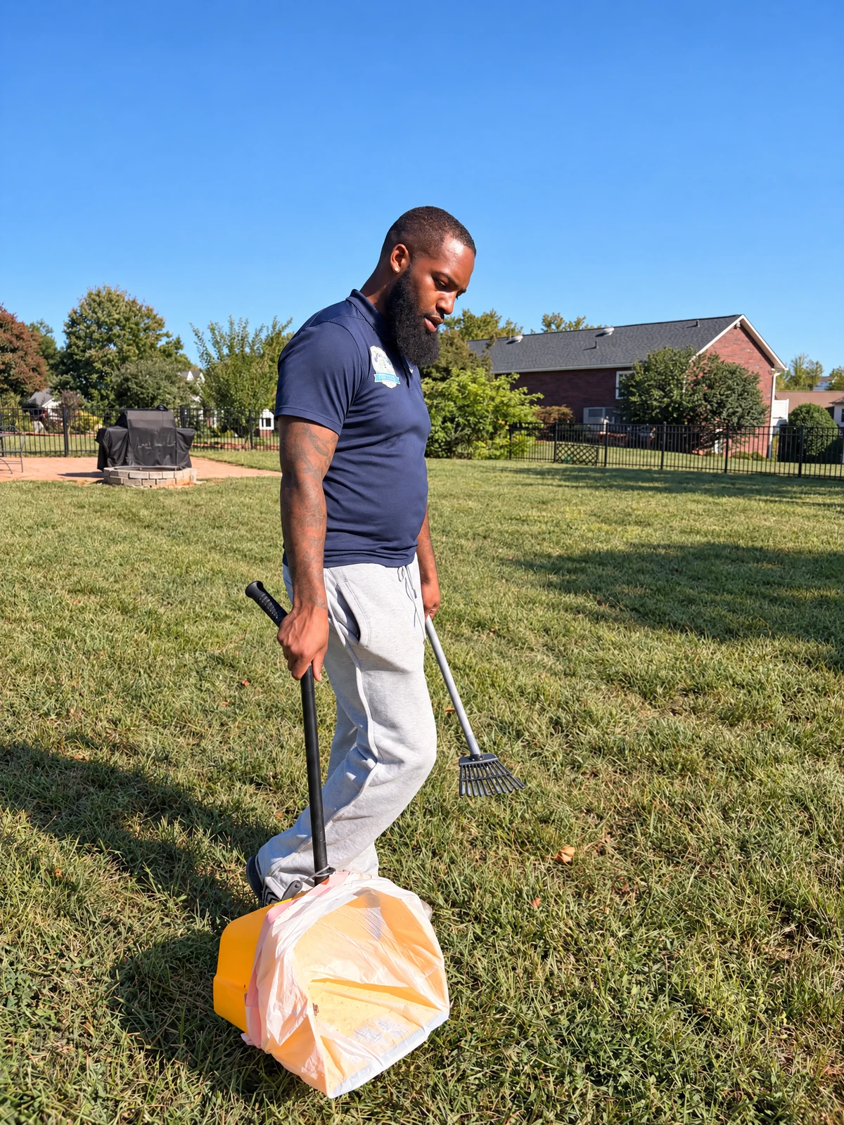 K9 Waste Solutions technician with cleanup tools in an actual residential yard; professionally retouched owner photo