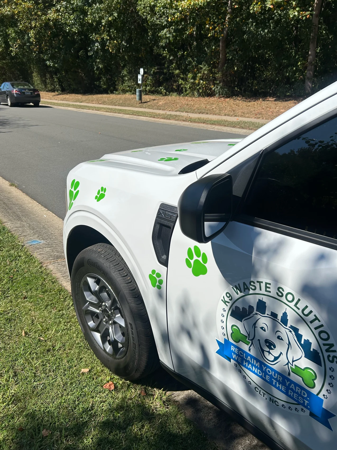 Close view of the real K9 logo and green paw decals on the company truck